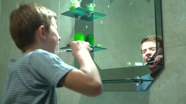 Jonge jongen tandenpoetsen in de badkamer — Stockvideo