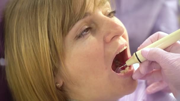 Kvinna vid tandhygienist och tandläkare klinik professionell tandblekning och ultraljud rengöring. Odontic och mun hälsa och hygien är viktig del av mänskligt liv som tandvård hjälpa med — Stockvideo