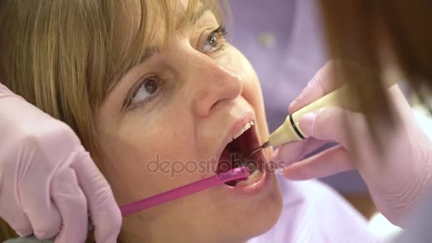 Woman at the dental hygienist and dentist clinic professional tooth whitening and ultrasound cleaning. Odontic and mouth health and hygiene is important part of human life that dentistry help with — Stock Video