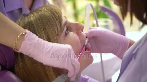 Mulher na clínica odontológica higienista e odontológica clareamento dental profissional e limpeza por ultrassom. Odontia e saúde bucal e higiene é parte importante da vida humana que a odontologia ajuda com — Vídeo de Stock