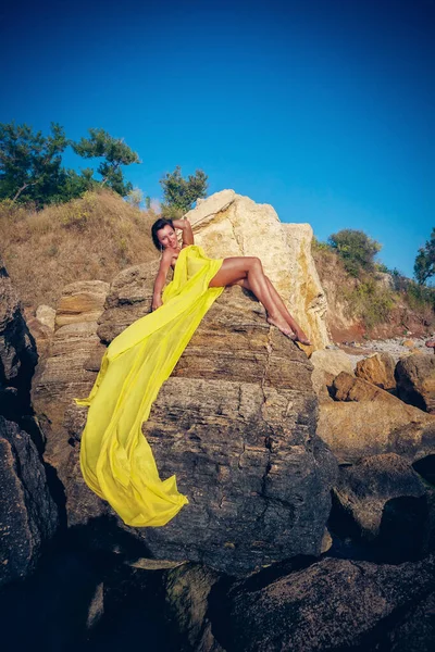 Sarı Kumaşlı Güzel Kadın Kayanın Üstünde — Stok fotoğraf