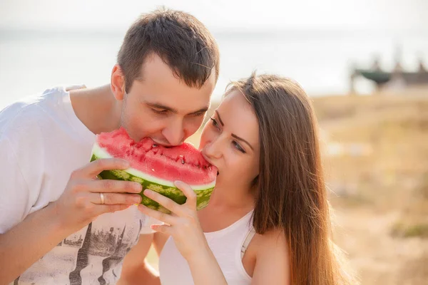 一緒に新鮮なメロンを食べる若いカップルの笑みを浮かべてください — ストック写真