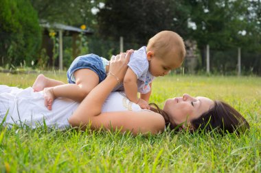 Mutlu anne ve bebeğinin açık havada portresi.