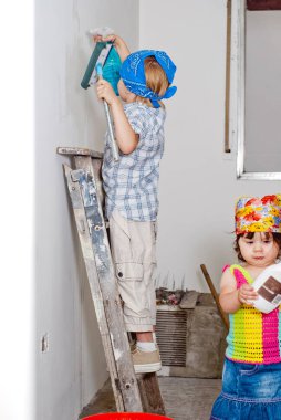 Küçük çocuklar tamirat sırasında odayı temizlerler.