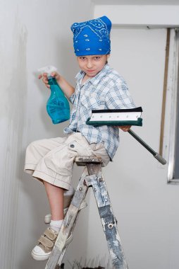 Genç çocuk tamirat sırasında odayı temizler.