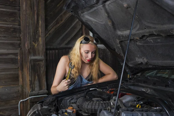 Девушка ремонтирует автомобиль — стоковое фото