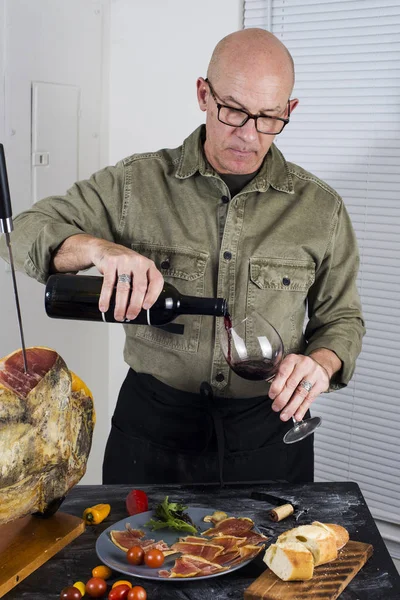 Mann schenkt Rotwein ein — Stockfoto