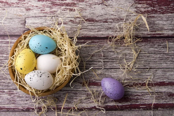 Easter eggs in a nest on a textured background — Stok fotoğraf