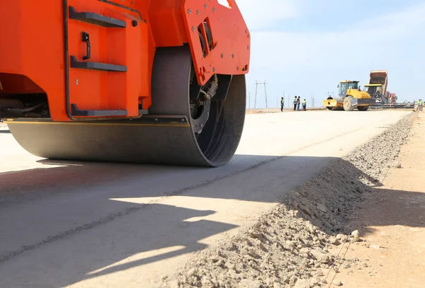 A road roller levels the ground for new asphalt. The construction of a new road.