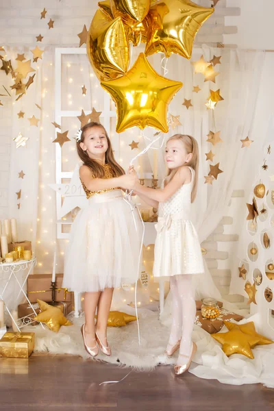 Duas meninas em uma decoração de Natal de ouro — Fotografia de Stock