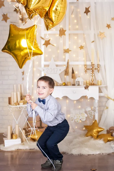 Niño en una decoración navideña de oro — Foto de Stock