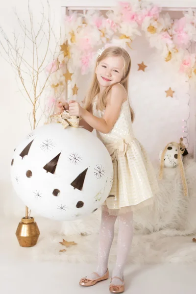 Menina loira sorridente bonito com uma enorme bola de Natal — Fotografia de Stock
