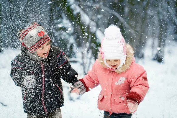 Щасливі діти сміються в прекрасному сніжному зимовому лісі — стокове фото