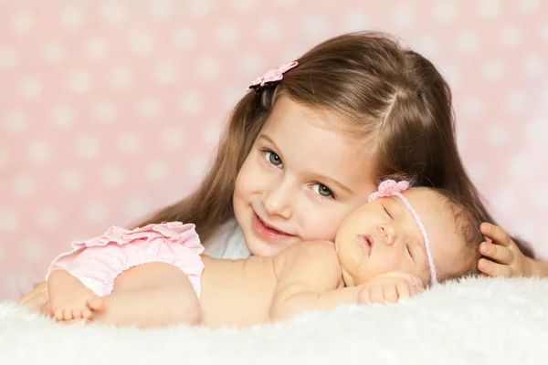 Menina bonito com uma irmã recém-nascida dormindo — Fotografia de Stock
