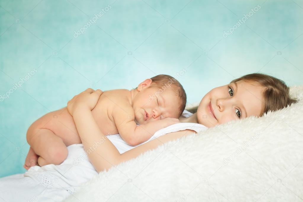Cute little girl with a sleeping newborn sister
