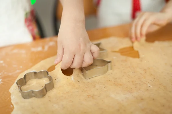 Children cutting cookies with molds for cookies