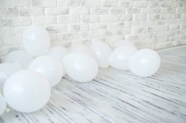 Beyaz tuğla duvar yakınındaki beyaz balonlar