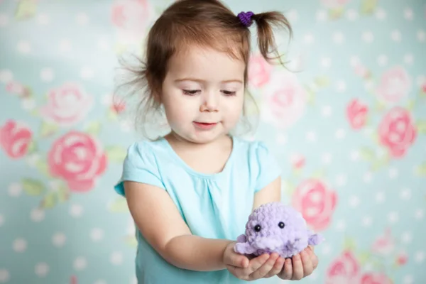 Meisje speelt met haar gebreide speelgoed — Stockfoto