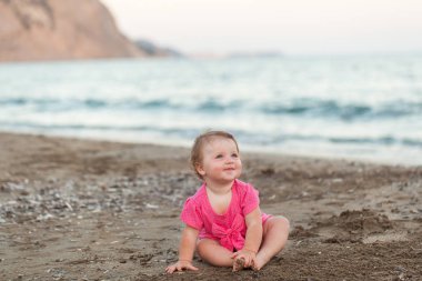 Sevimli küçük kız sahilde oturmuş
