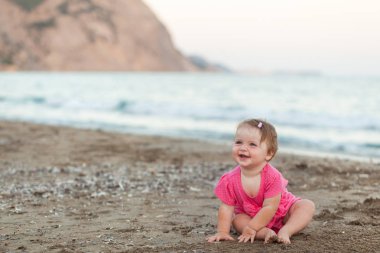 Sevimli küçük kız sahilde oturmuş
