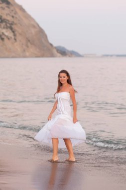 bir kumsalda yürüyen güzel genç kadın