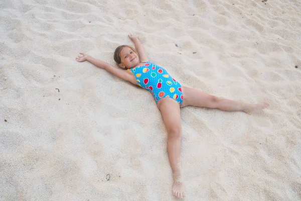 Sevimli kız kumsalda oynarken — Stok fotoğraf