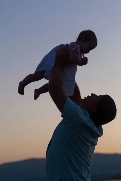 Pai feliz com uma pequena filha no pôr do sol — Fotografia de Stock