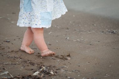 Şirin bebek kızlar bacaklar bir plajda