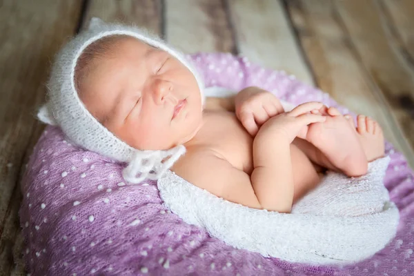 Bebê recém-nascido adormecido em um travesseiro violeta — Fotografia de Stock