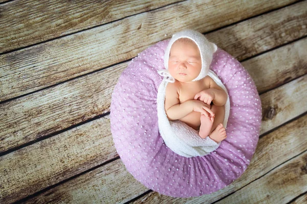 Schlafendes Neugeborenes auf einem violetten Kissen — Stockfoto
