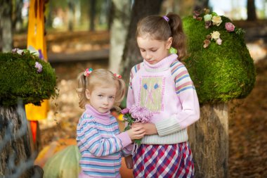 Sonbahar parkta gülümseyen kız kardeş