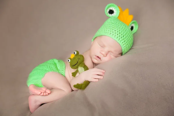 Schattige pasgeboren baby in een kikker kostuum — Stockfoto