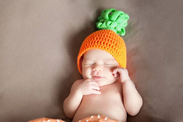 Bebé recién nacido con una zanahoria o un sombrero de calabaza de punto —  Fotos de Stock