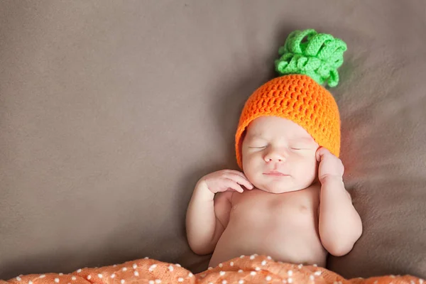 Pasgeboren baby het dragen van een gebreide wortel of pompoen hoed — Stockfoto