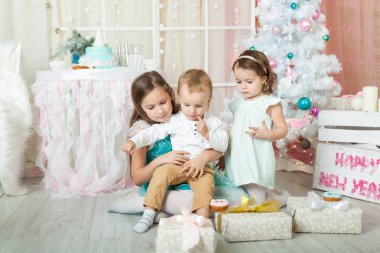 Çocuklar Noel süslemeli bir stüdyoda pastel renklerle