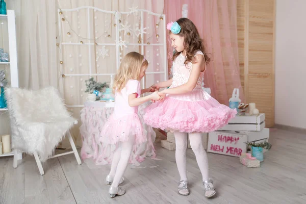 Noel süslemeli bir stüdyoda pastel renklerde iki kız kardeş.