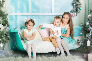 Çocuklar Noel süslemeli bir stüdyoda pastel renklerle