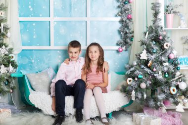 Çocuklar Noel süslemeli bir stüdyoda pastel renklerle