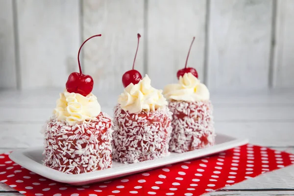 Red Cupcakes Whipped Cream Cherry Coconut Chips Red Fabric — Stock Photo, Image