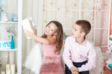 Çocuklar Noel süslemeli bir stüdyoda pastel renklerle