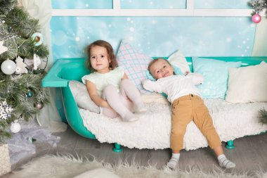 Çocuklar Noel süslemeli bir stüdyoda pastel renklerle