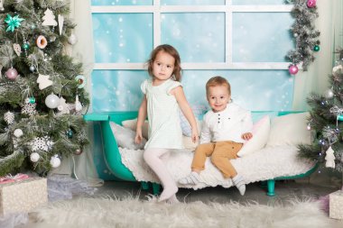 Çocuklar Noel süslemeli bir stüdyoda pastel renklerle