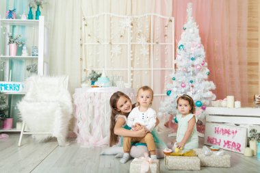 Çocuklar Noel süslemeli bir stüdyoda pastel renklerle