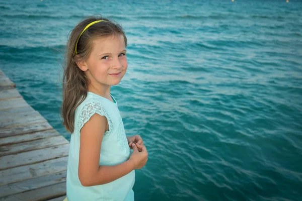 Linda chica en traje de verano staing en un muelle cerca del mar —  Fotos de Stock