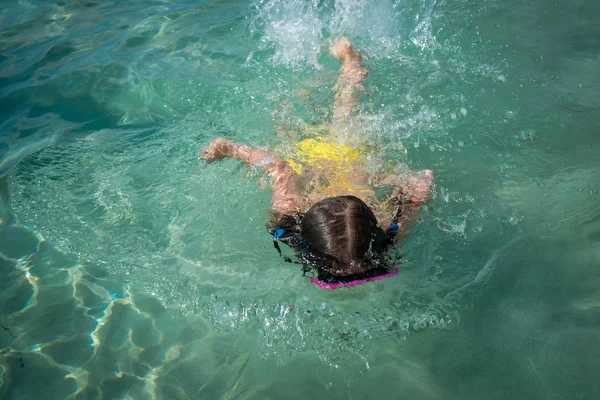 Yüzme maskeli küçük kız temiz turkuaz suda yüzmek