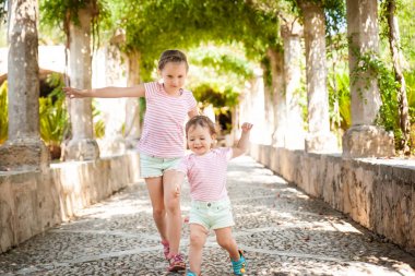 Little girls playing in Alfabia gardens in Mallorca clipart