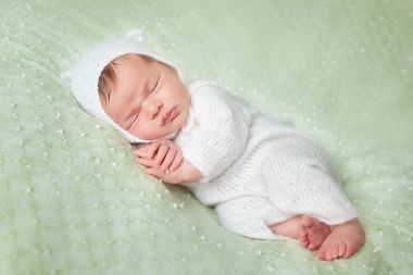 Sevimli uyuyan yeni doğan bebek beyaz örme kabarık kedi kostüm