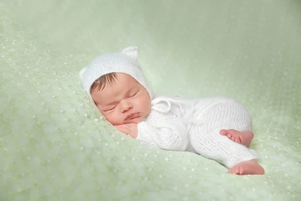 Bonito bebê recém-nascido adormecido em traje de gatinho macio de malha branca — Fotografia de Stock