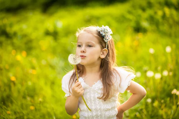 Kleines Mädchen bläst Löwenzahn — Stockfoto