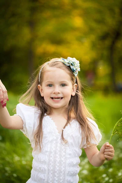 Beyaz çiçekli bir alandaki küçük kız — Stok fotoğraf
